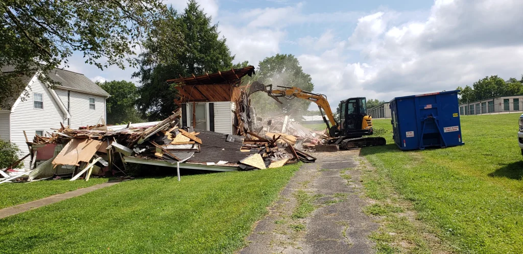 Reliable Outcomes Excavation excavator structure demolition with dumpster.